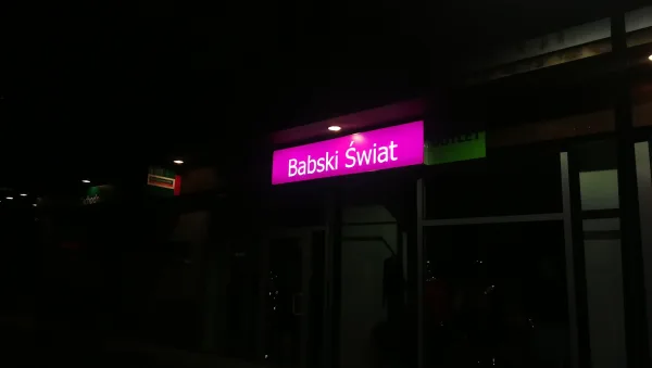 Babski Świat — szyld w dzień i w nocy